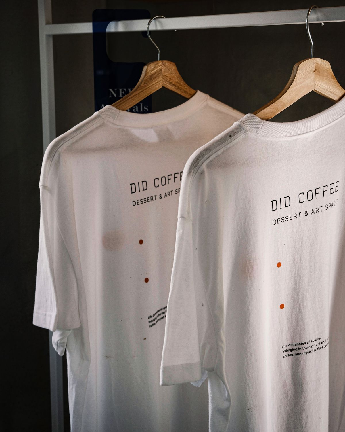 Two branded white t-shirts on hangers