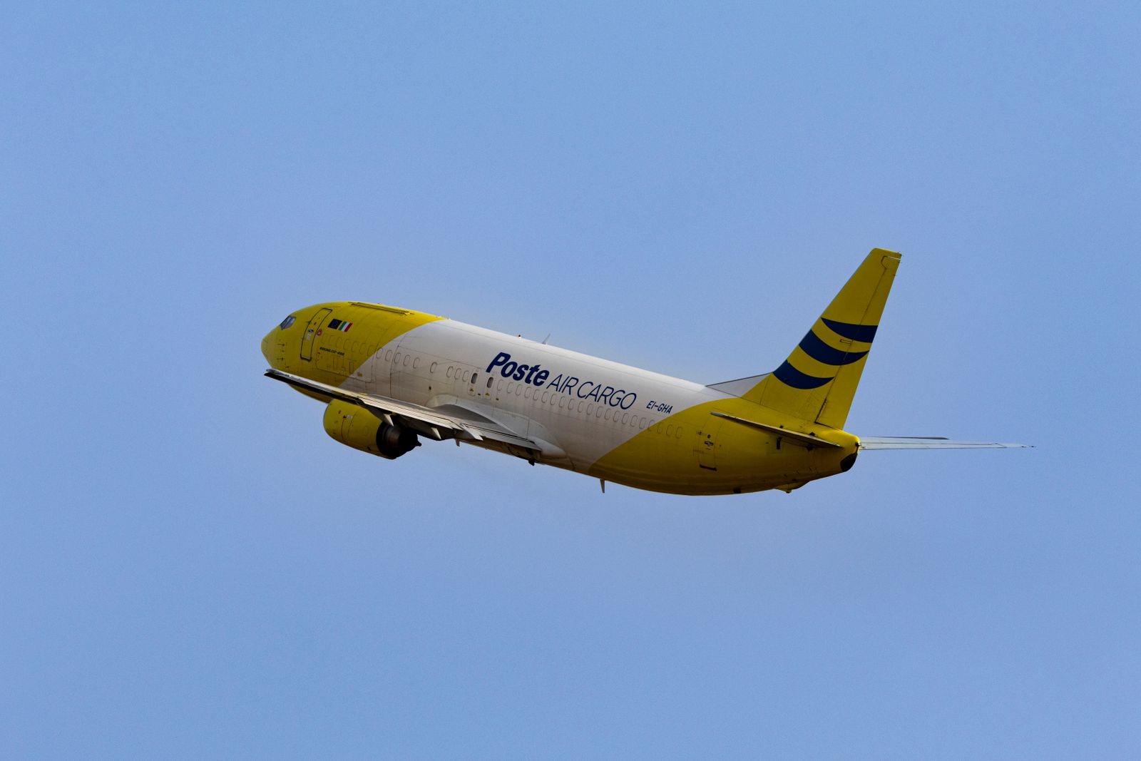 Cargo aircraft taking off into a blue sky