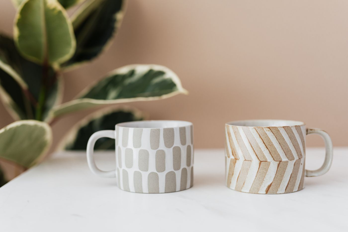 Two patterned ceramic mugs on a table