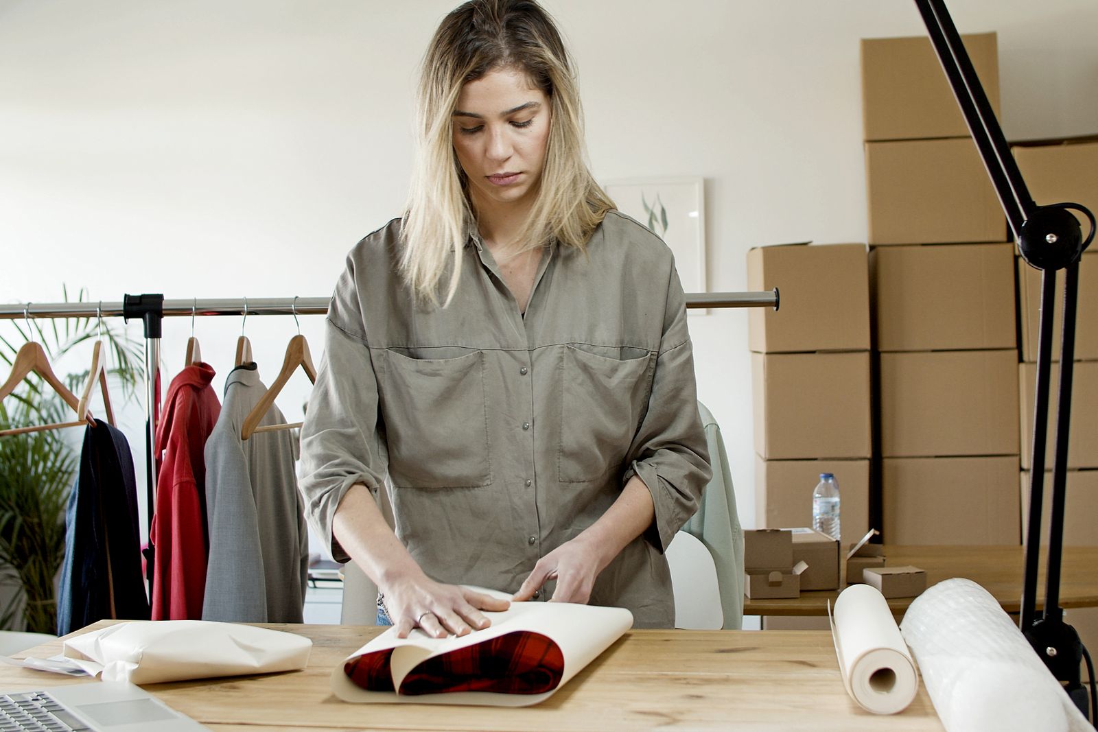 Woman wrapping an order in branded tissue paper