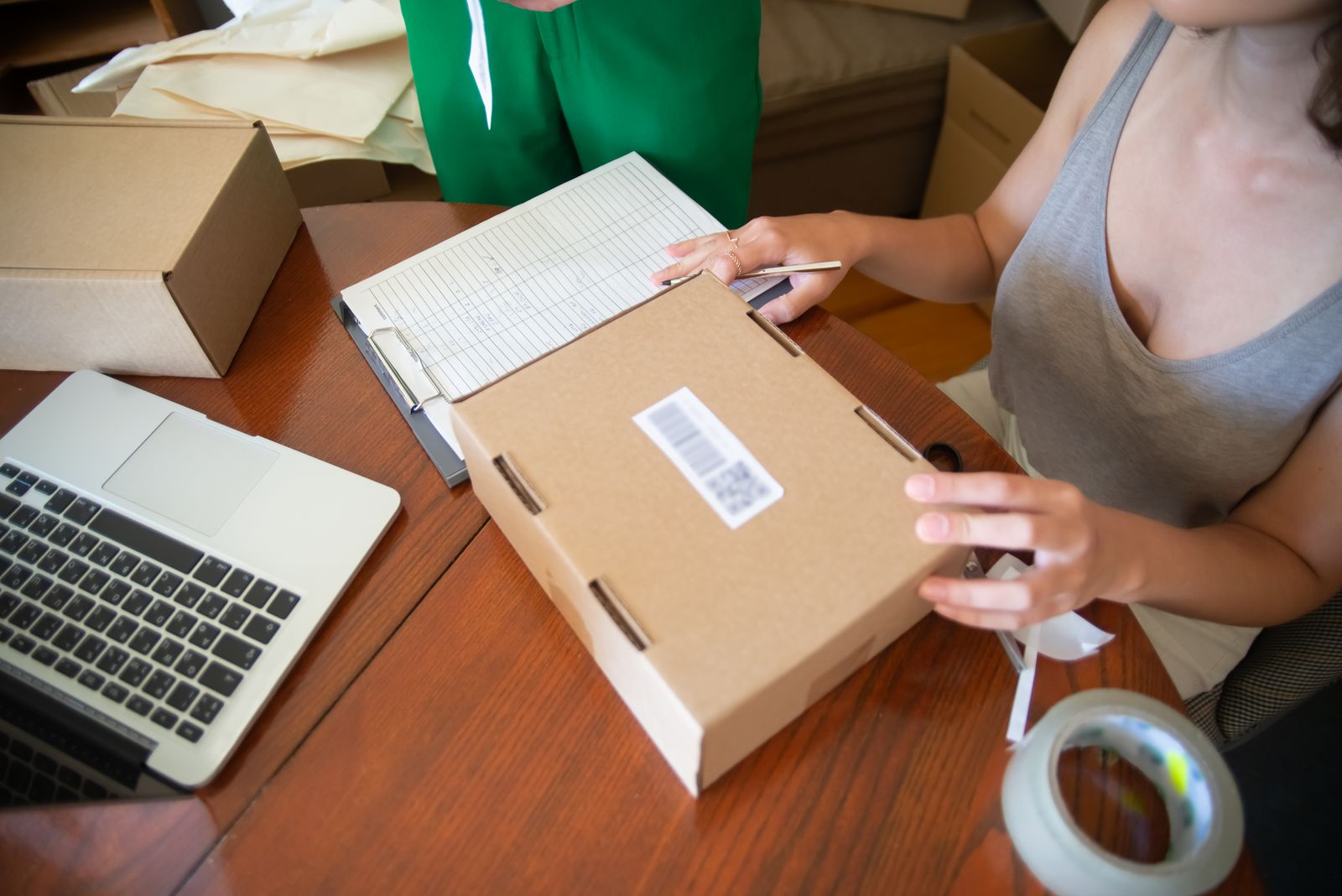 Online store orders being packed beside a laptop